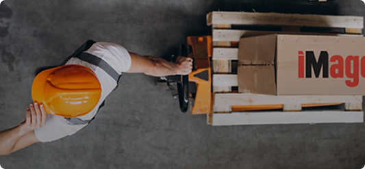 A person in an orange vest is loading boxes.